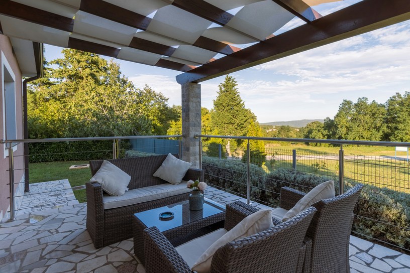 Cozy concrete patio with pergola and lounge furniture in Old Bridge NJ