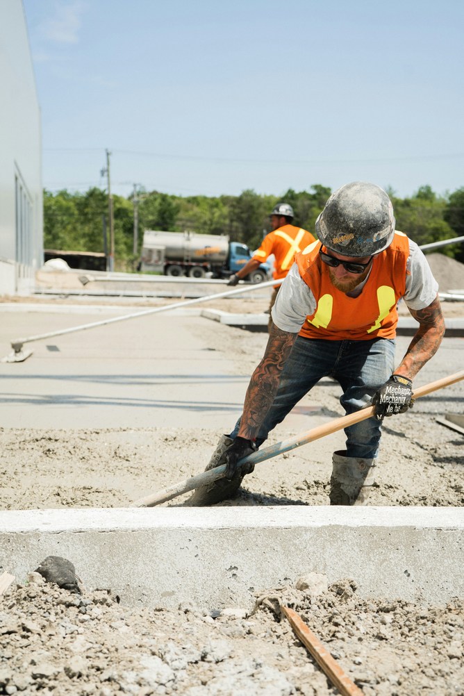 Construction worker screeding fresh concrete in Old Bridge NJ